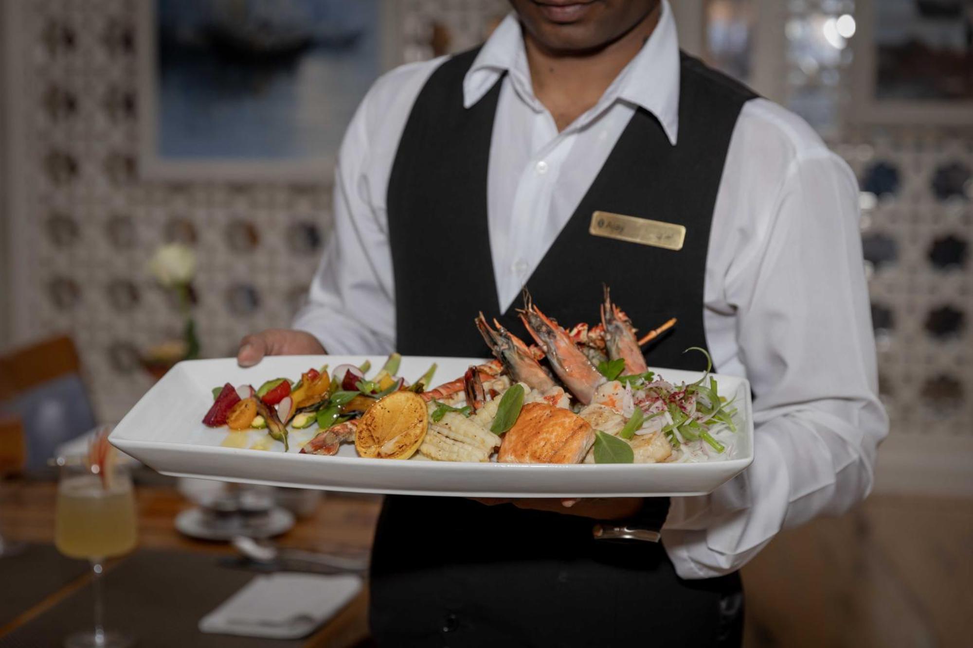 インターコンチネンタル アル ジュバイル Al Al Jubail エクステリア 写真 A waiter serving food