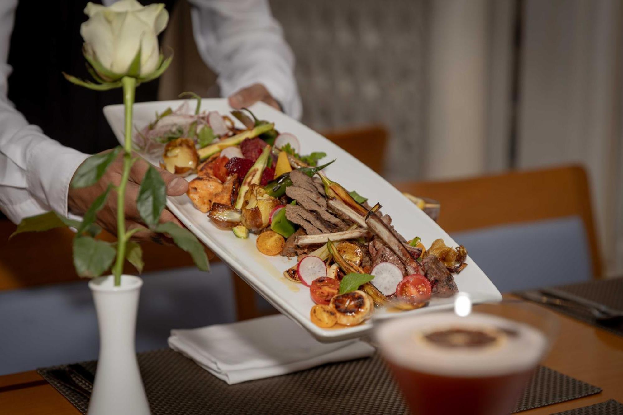 インターコンチネンタル アル ジュバイル Al Al Jubail エクステリア 写真 A waiter serving a plate of food